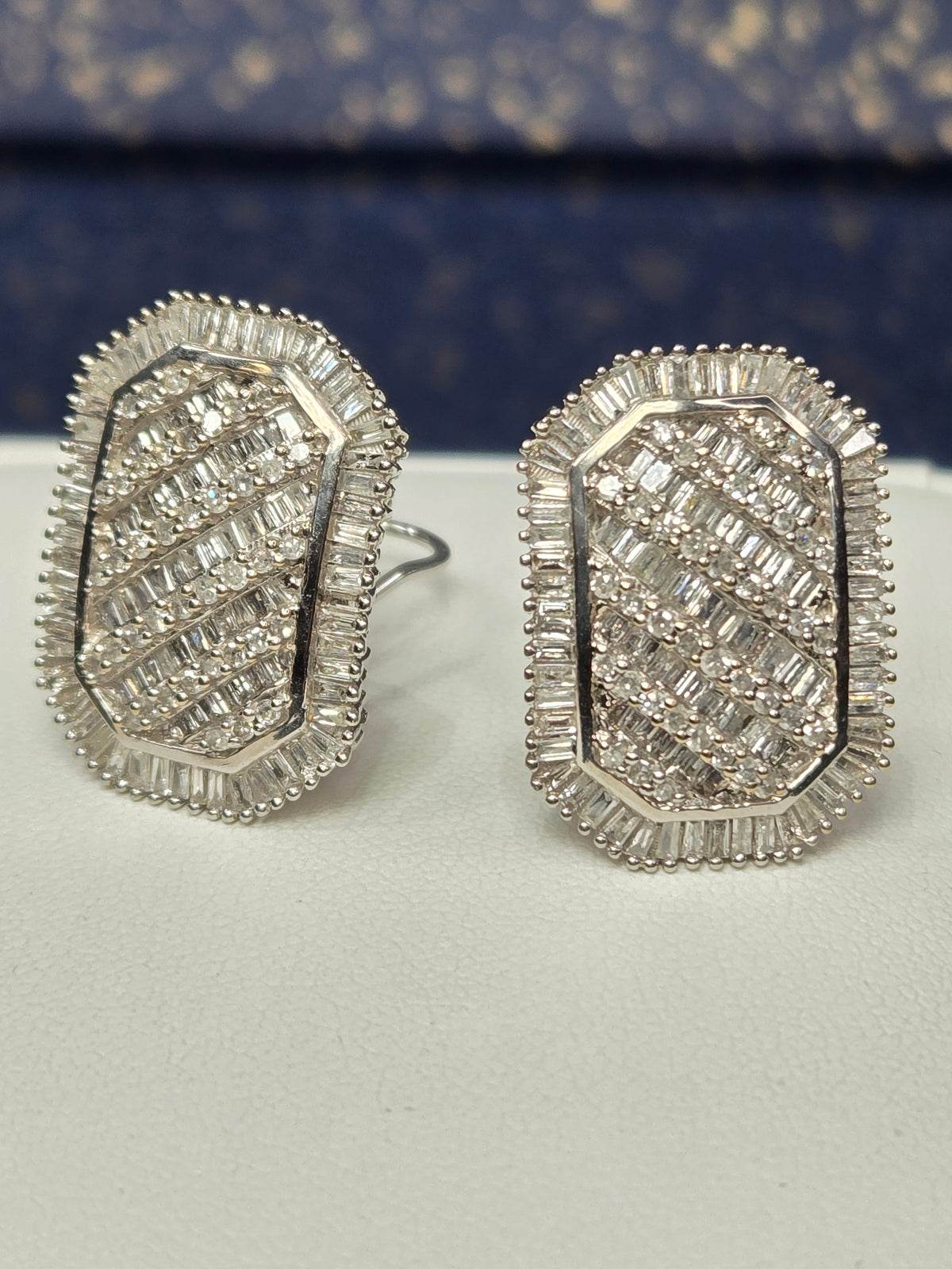 pair of 14k white gold earrings front view showing baguette and round diamonds