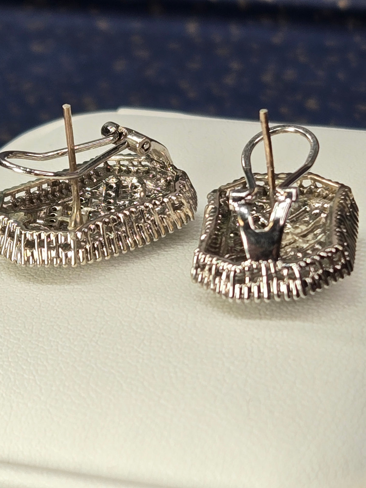 angled close-up showing pavé shoulders and omega backs