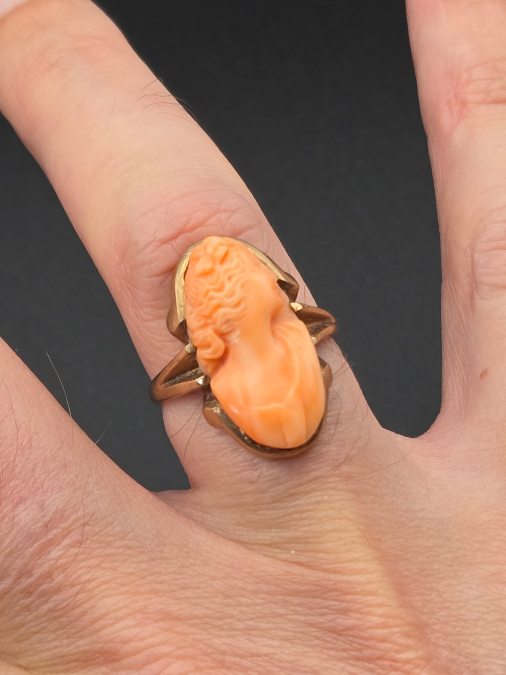 ring displayed on hand showing scale and cameo detail