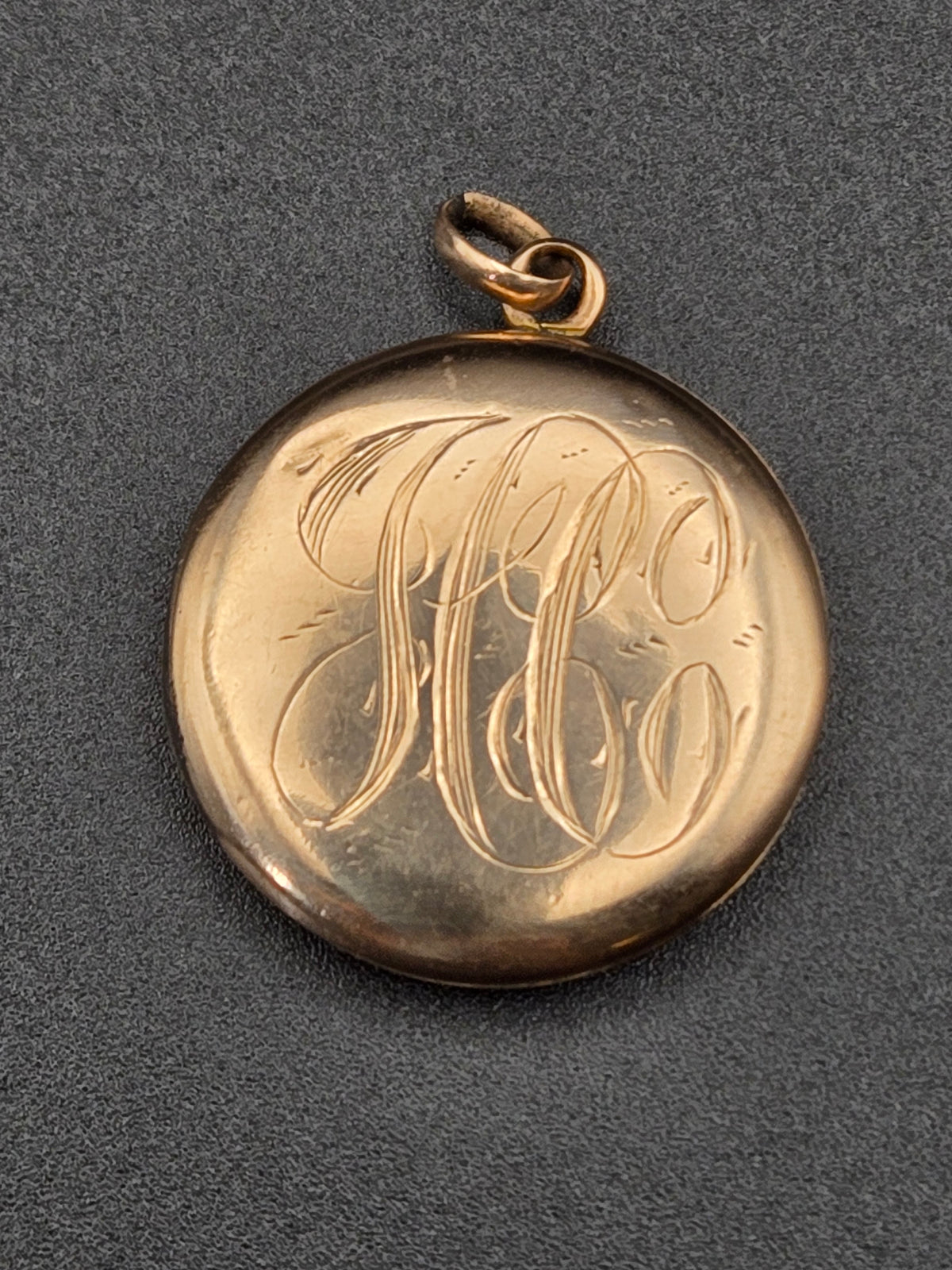front view of small round monogram photo locket with engraved cartouche