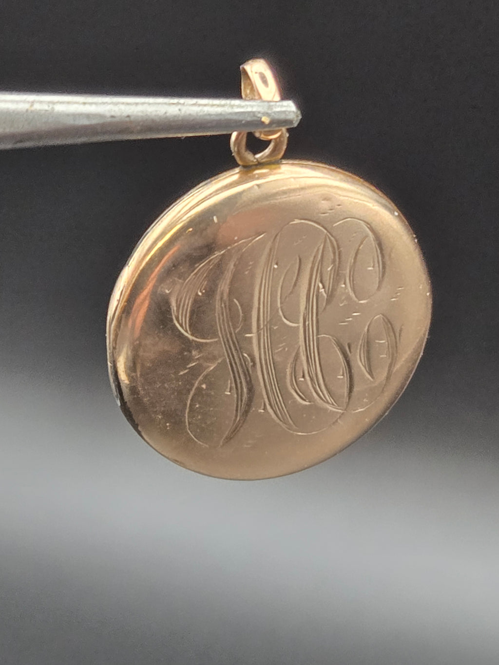 side view of locket on chain showing thickness and bail