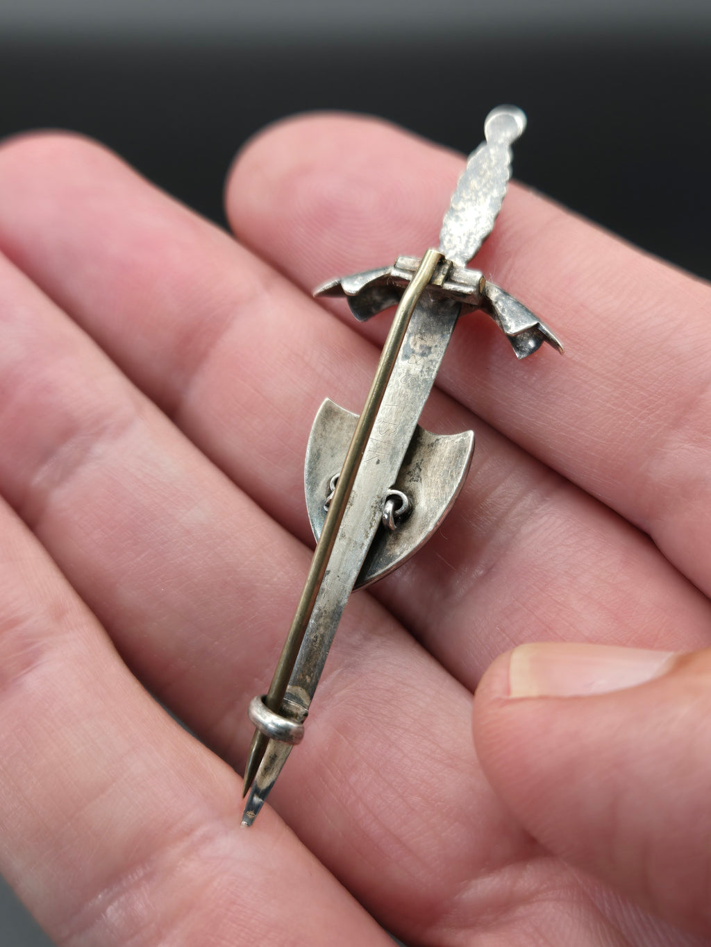 angled detail of brooch blade and stone inlay