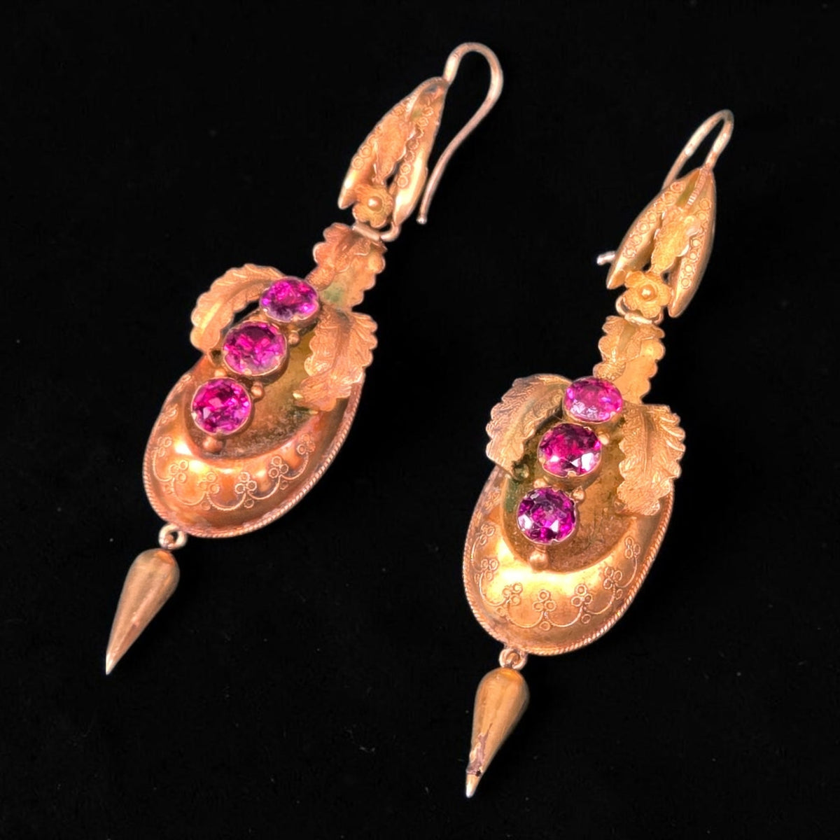 Victorian 18k gold drop earrings with deep garnet stones and filigree detail.