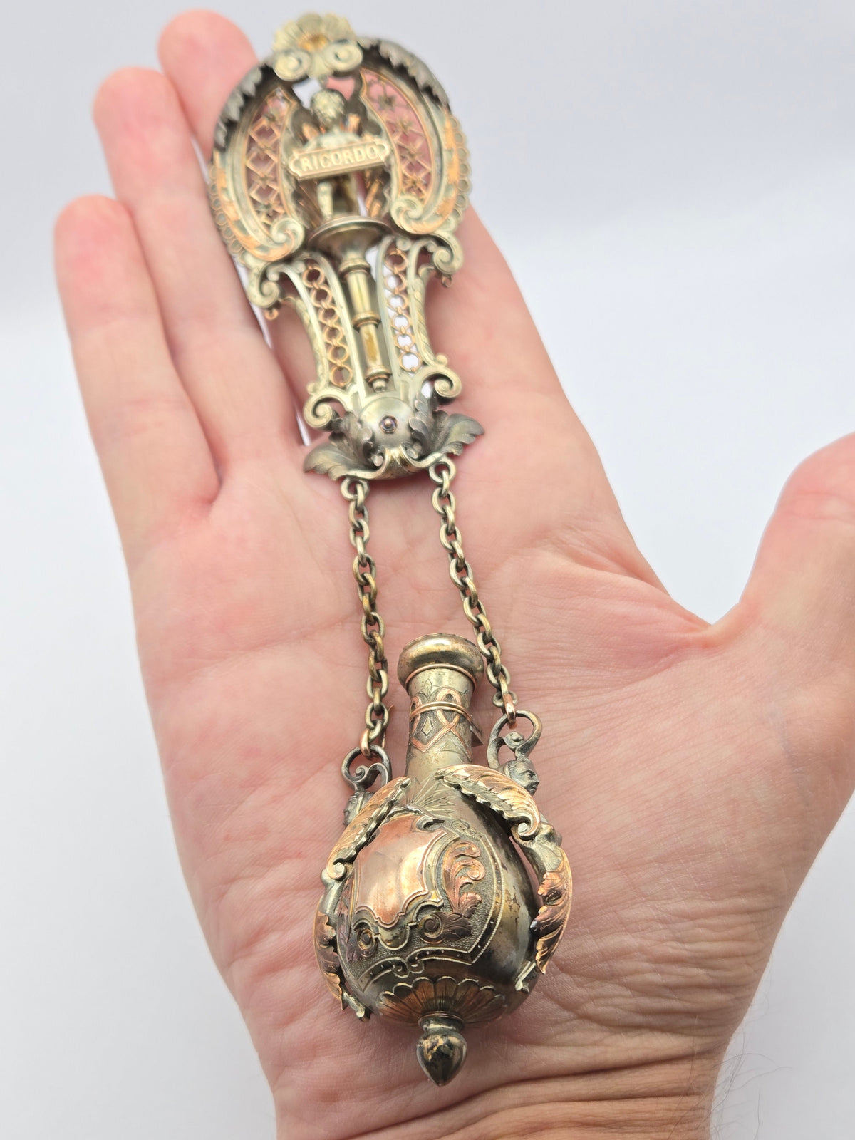 back view showing ornate filigree and suspension ring